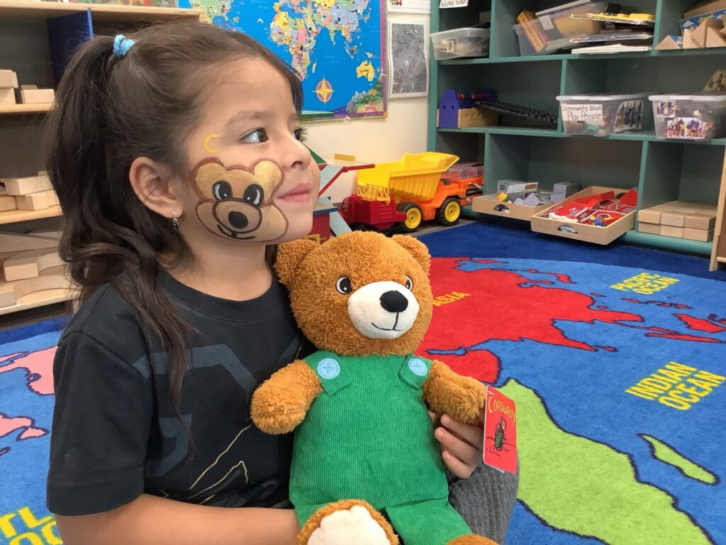a student with a teddy bear in the classroom learning.